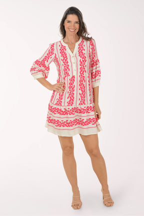 Woman wearing a pink and white embroidered dress on a white background