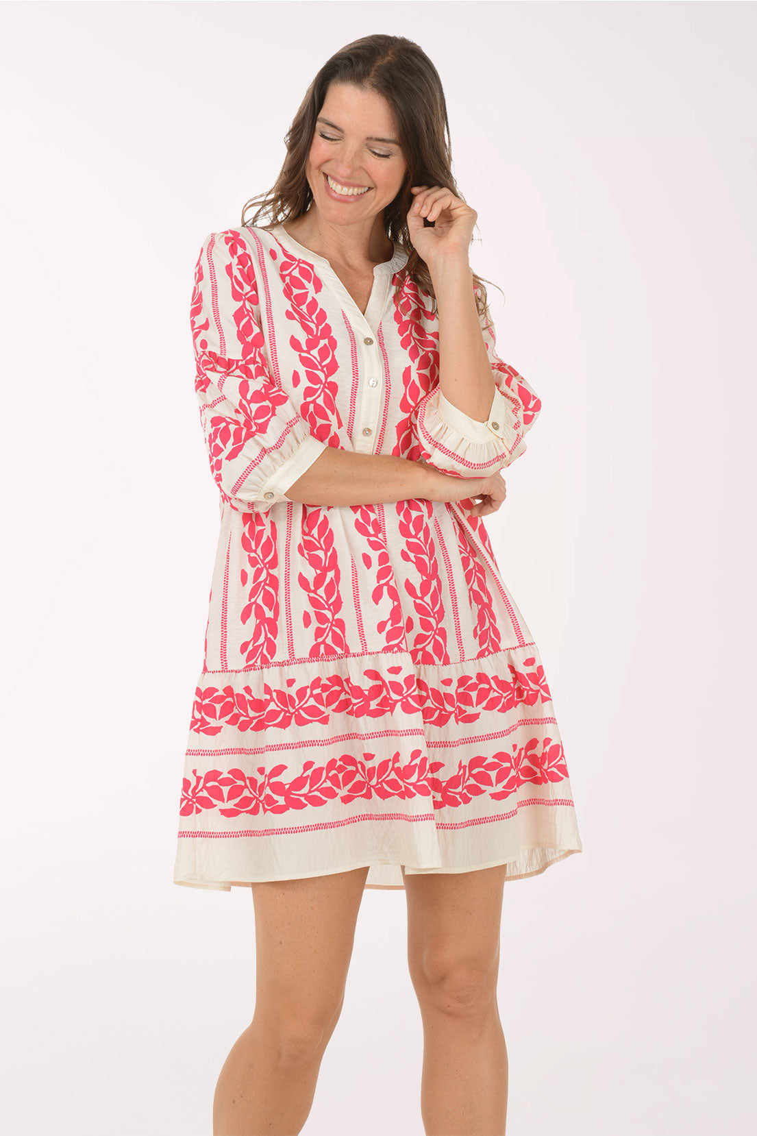 Woman wearing a pink and white embroidered dress on a white background