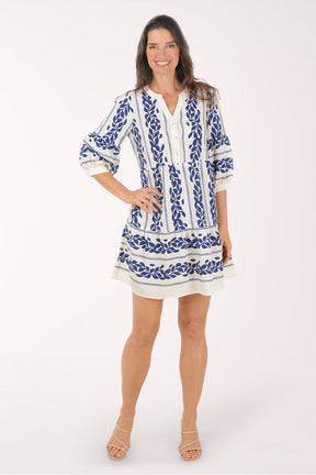 Woman wearing a blue and white patterned dress on a white background
