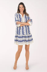 Woman wearing a blue and white patterned dress on a white background