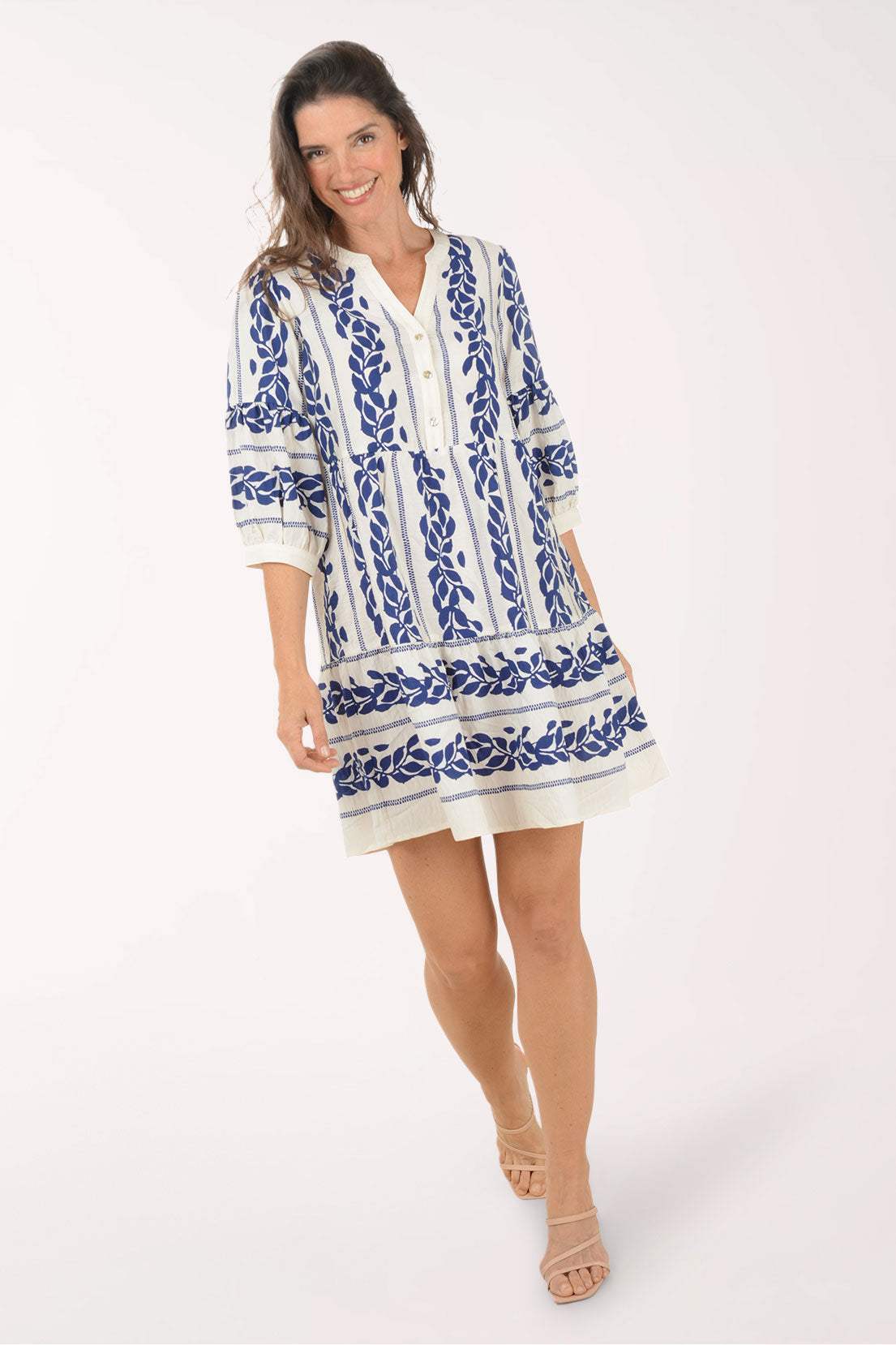 Woman wearing a blue and white patterned dress on a white background