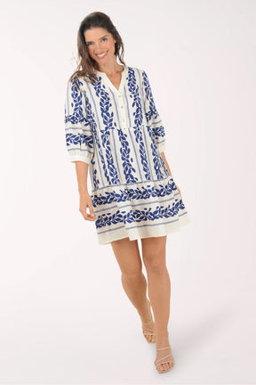 Woman wearing a blue and white patterned dress on a white background