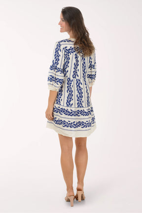 Woman wearing a blue and white patterned dress on a white background