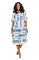 Woman wearing a blue and white patterned midi dress on a white background.