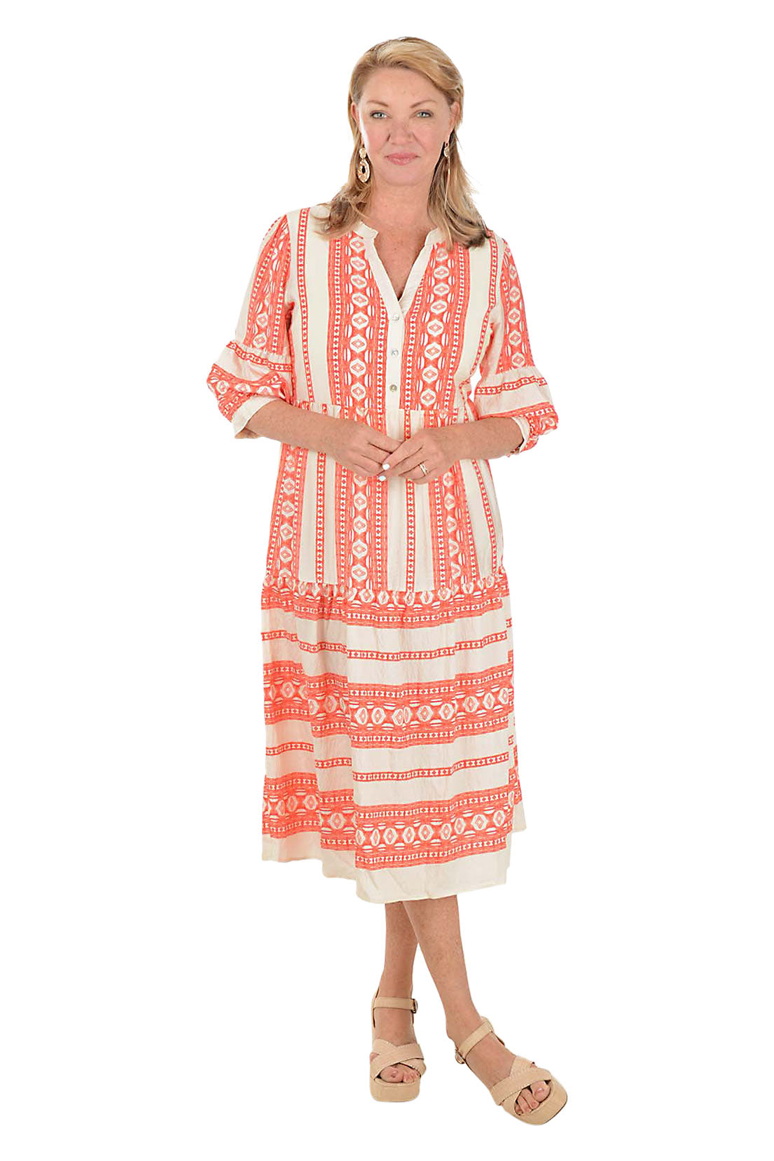 Woman wearing a coral and white patterned midi dress on a white background.