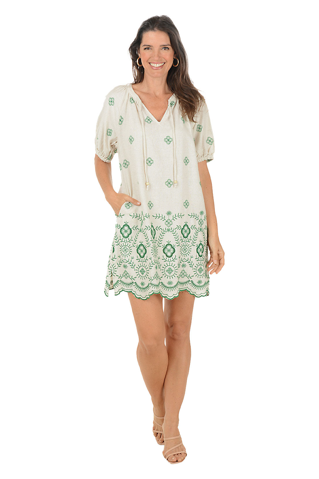 Woman wearing a green and white patterned dress on a white background.