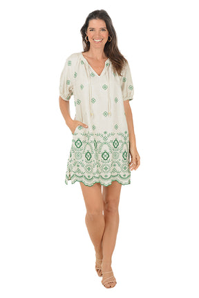Woman wearing a green and white patterned dress on a white background.