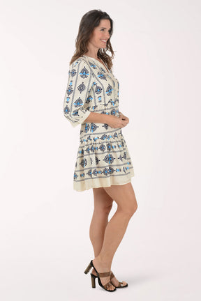 Woman wearing a white dress with blue floral patterns on a white background