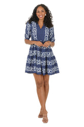 Woman wearing a blue patterned dress on a white background.