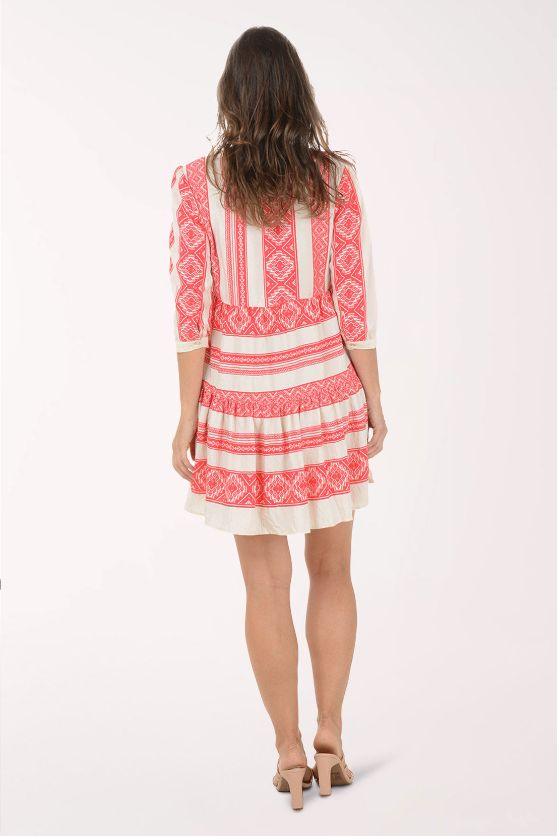 Woman wearing a red and white patterned dress on a white background