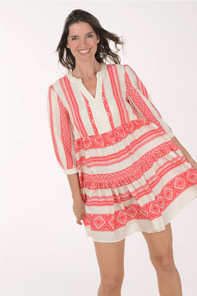 Woman wearing a red and white patterned dress on a white background
