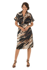 Woman wearing a brown patterned dress on a white background.