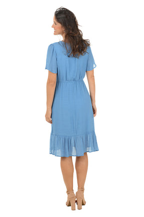 Woman wearing a blue dress on a white background. Back shot.