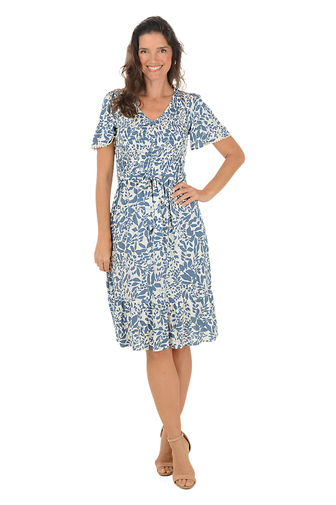 Woman wearing a blue floral dress on a white background.
