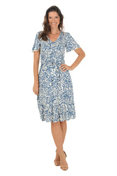 Woman wearing a blue floral dress on a white background.