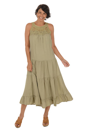 A woman wearing a khaki halter midi dress with a crochet neckline. 