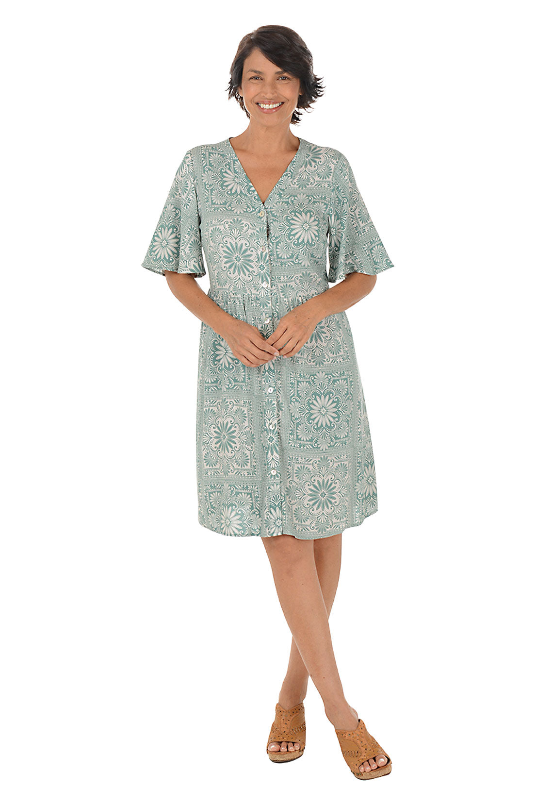 Woman wearing a patterned dress on a white background.