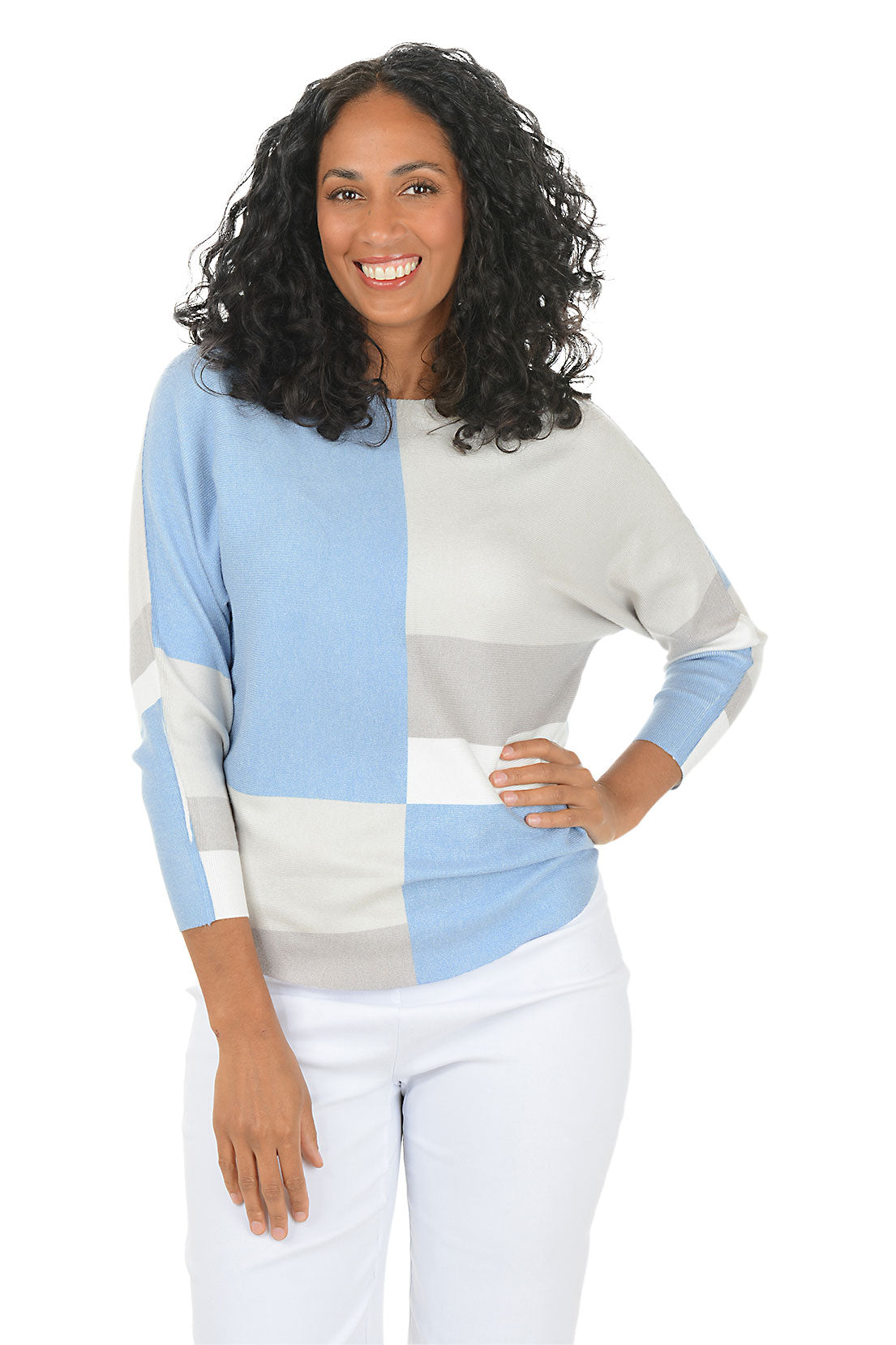 Woman wearing a blue and grey geometric block sweater with dolman sleeves on a white background.