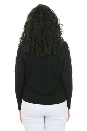 Woman wearing a black sweater with white bow embellishments on the sleeves on a white background. Back shot.