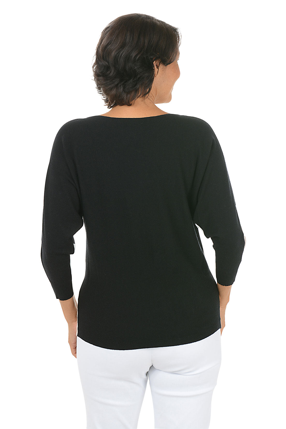 Woman wearing a color-blocked sweater with beige, black, and white design on a white background. Back shot.