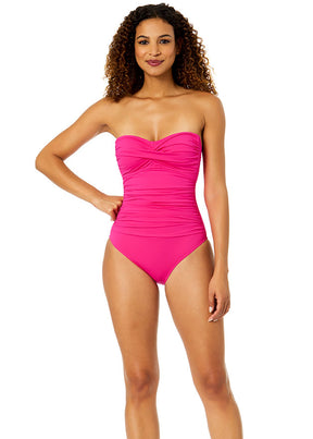 Woman wearing a pink strapless swimsuit on a white background