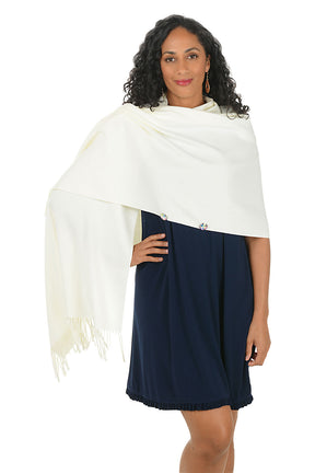 Woman wearing a white shawl with fringes on a white background.