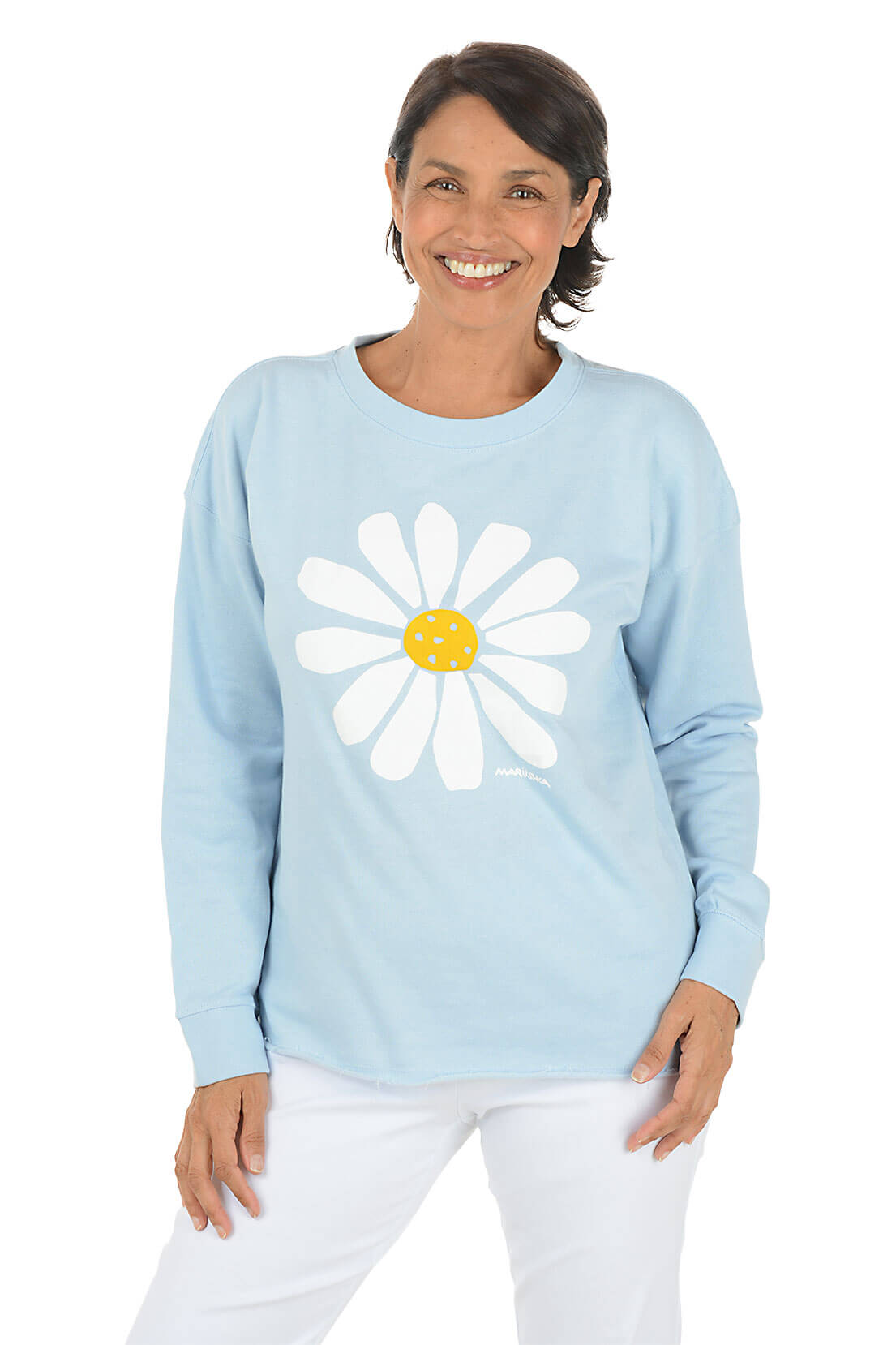 Woman wearing a light blue sweatshirt with a white daisy design on a white background