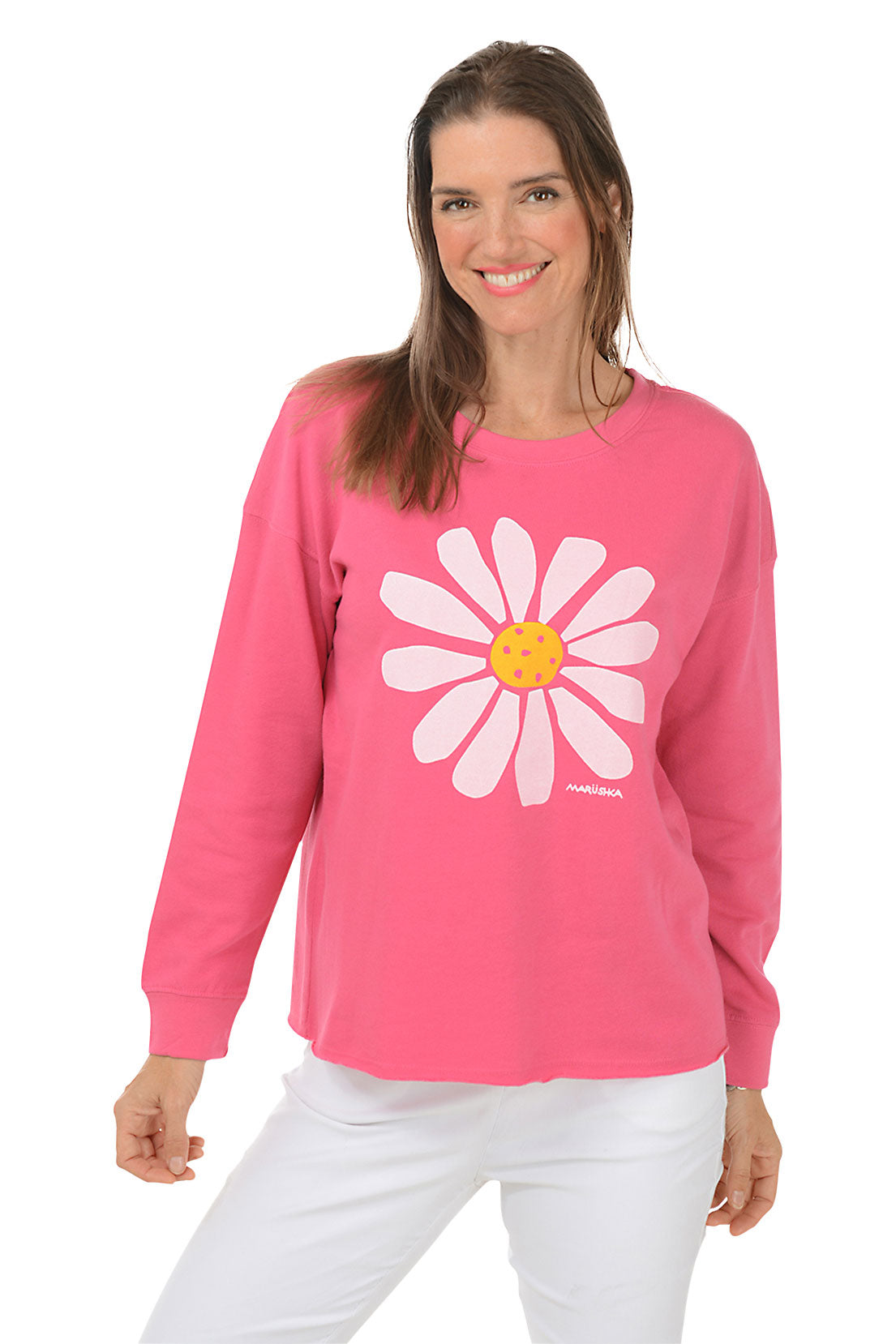 Woman wearing a pink long-sleeve sweater with a white daisy design on a white background.
