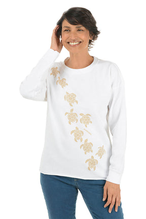 Woman wearing a white long-sleeve shirt with turtle designs on a white background