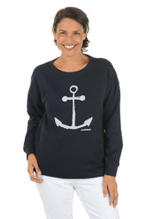 Woman wearing a black sweater with a white anchor design on a white background