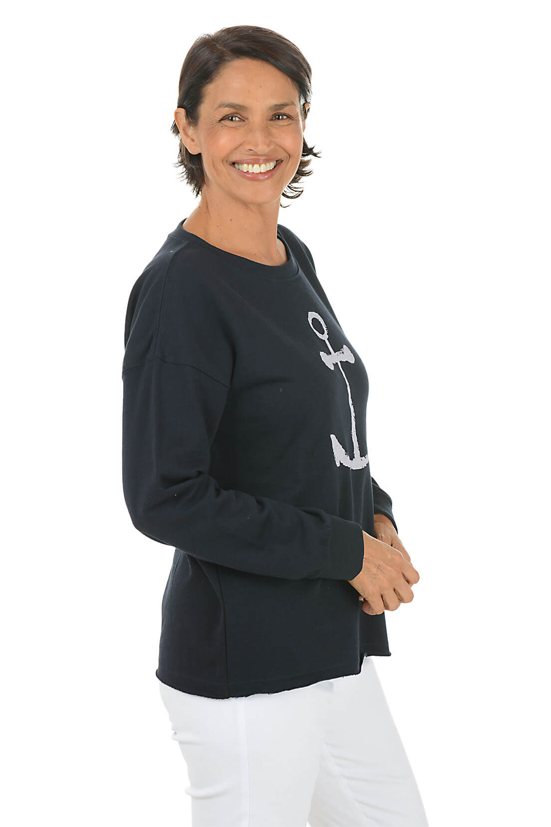 Woman wearing a black sweater with a white anchor design on a white background