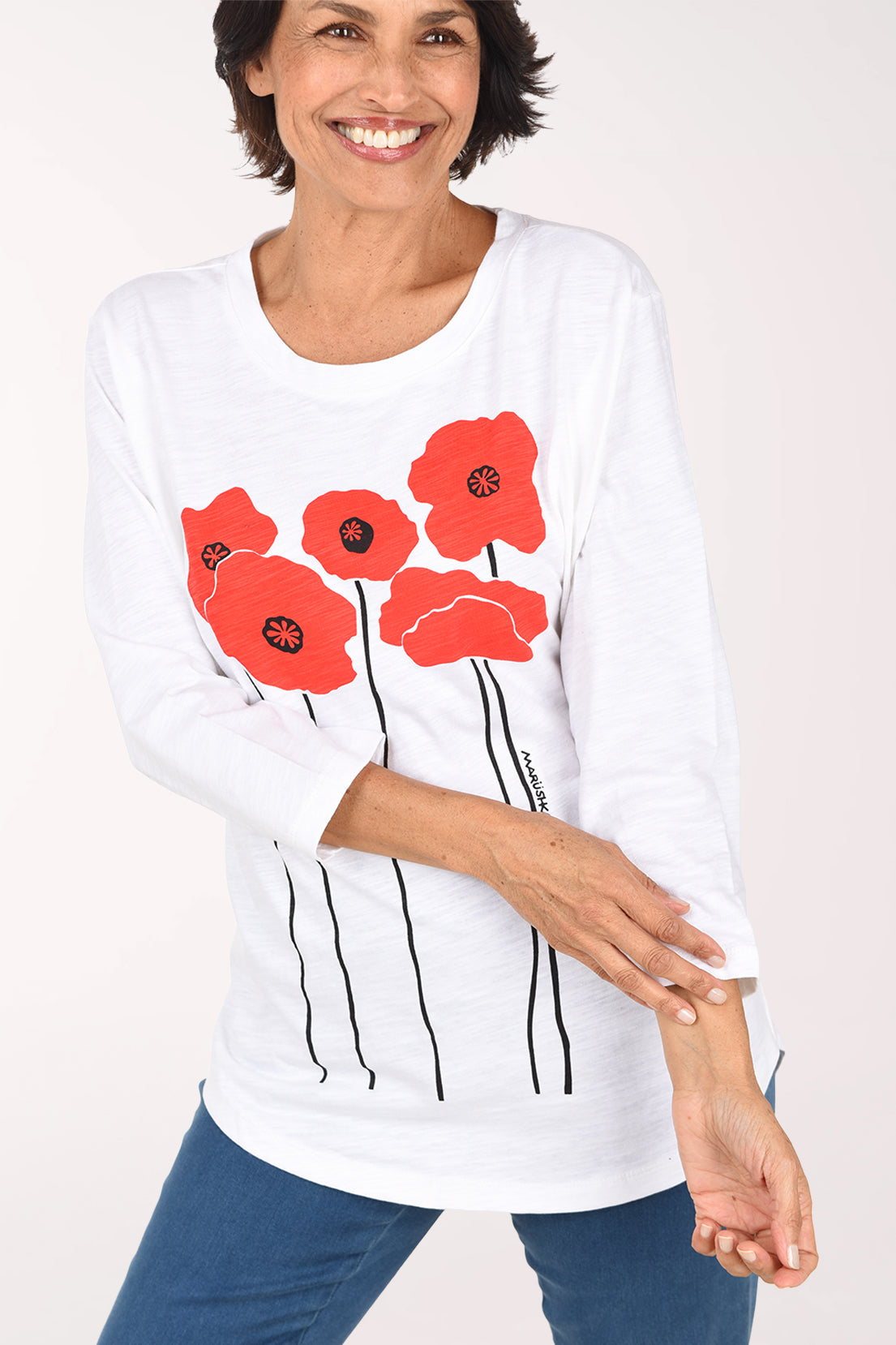 Front view of the white cotton tunic, showing the cluster of red poppies with black centers and the slub knit texture