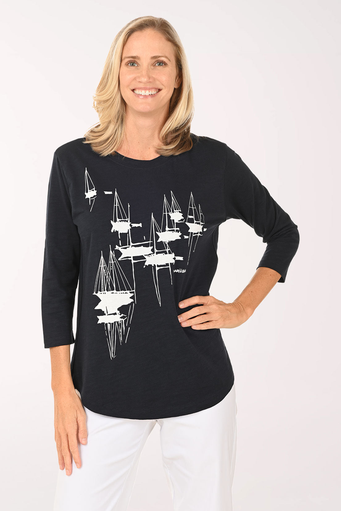 Woman wearing a navy and white top with sailboats
