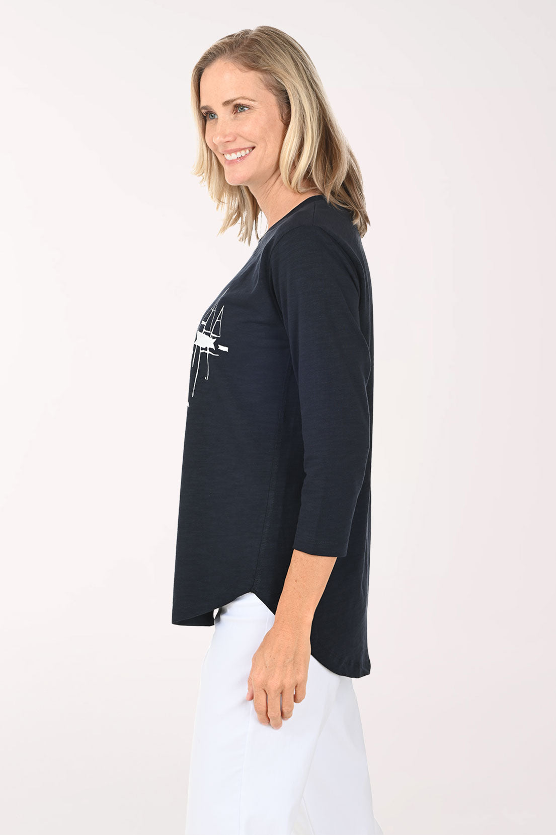 Woman wearing a navy and white top with sailboats