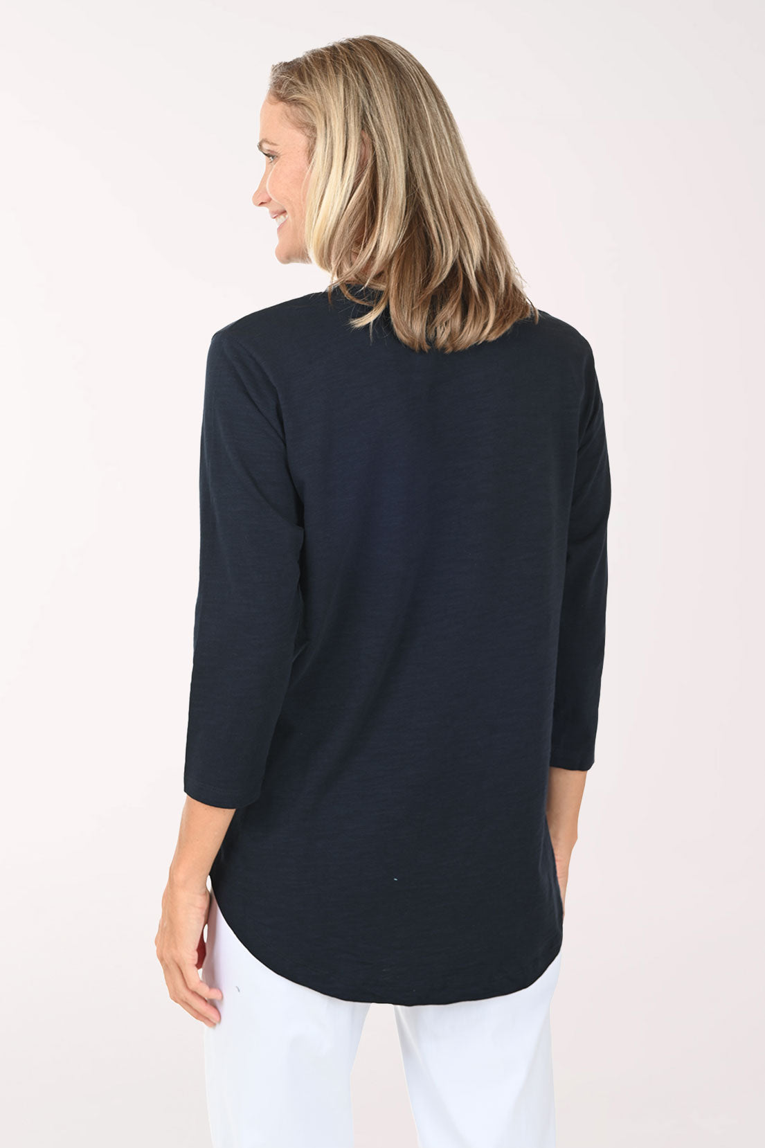 Woman wearing a navy and white top with sailboats