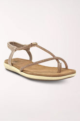 Champagne flat thong sandal with a rhinestone T-strap and toe loop, elastic slingback ankle strap, tan cushioned footbed and cream sole, shown from the side.