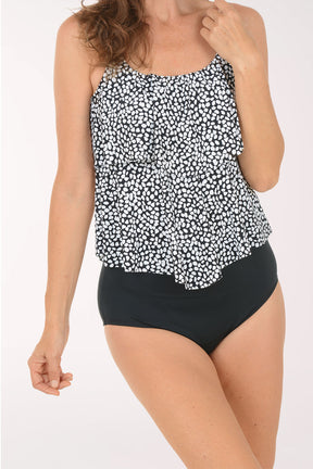 Woman wearing a black and white patterned tank top and black high-waisted bikini bottoms on a white background. Detail shot.