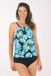 Woman wearing a black swimsuit with blue floral pattern on a white background.