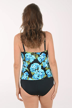 Woman wearing a black swimsuit with blue floral pattern on a white background. Back shot.