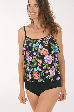 Woman wearing a floral tankini top and black bottoms on a white background. Detail shot.