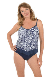 A woman wearing a blue and white one piece swimsuit with a flutter hem.