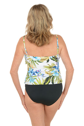 A woman wearing a double tiered white tankini top with a blue and green floral pattern. Back shot.