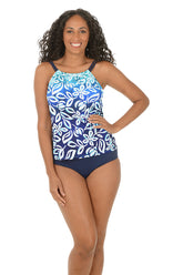 A woman wearing a blue multi tropical print tankini halter top.