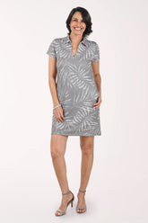Woman wearing a gray dress with leaf pattern on a white background