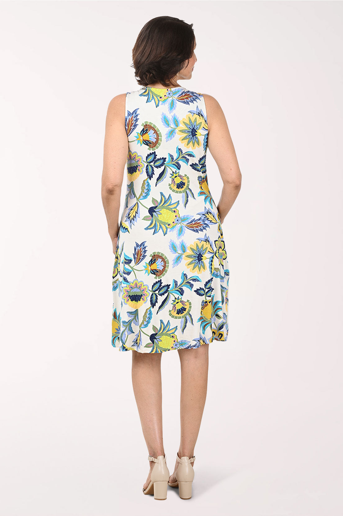 Woman wearing a floral sleeveless dress on a white background