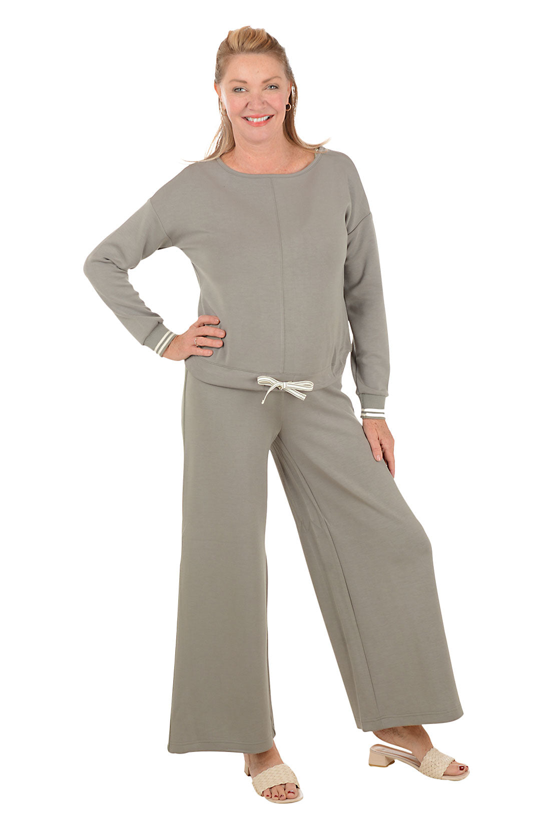 Woman wearing a gray lounge set on a white background.