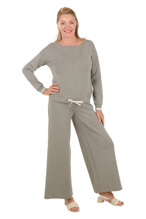 Woman wearing a gray lounge set on a white background.
