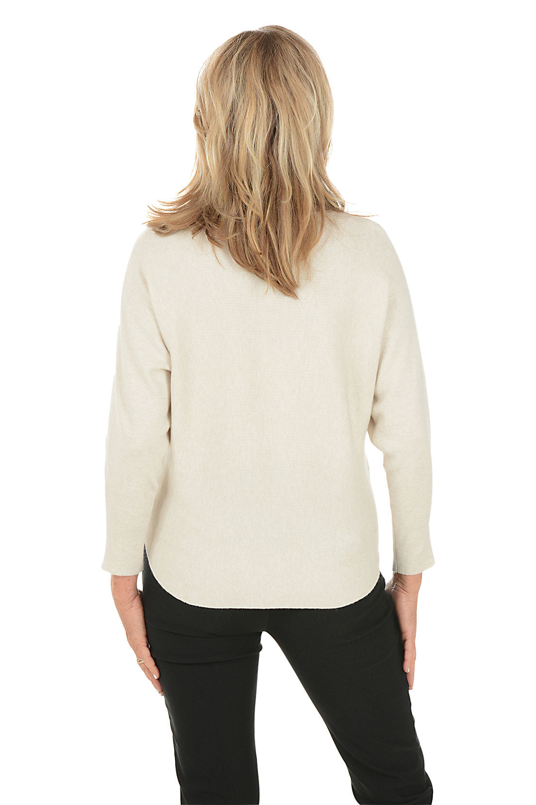 Woman wearing a cream sweater with black floral designs on a white background. Back shot.