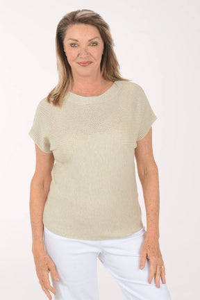 Woman wearing a beige short-sleeve top and white pants on a white background