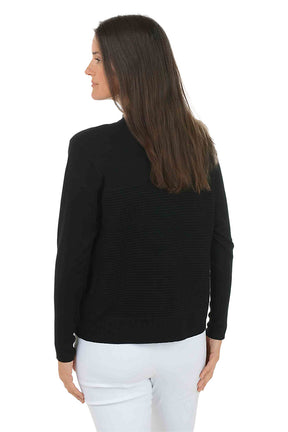 Woman wearing a black cardigan over a white top on a white background. Back shot.